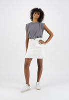 Gray sleeveless top paired with a white denim skirt, worn with white sneakers, showcasing a casual summer outfit.