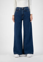 Wide-leg blue denim jeans with high waist paired with a fitted white knit top, showcasing a stylish modern fashion look.