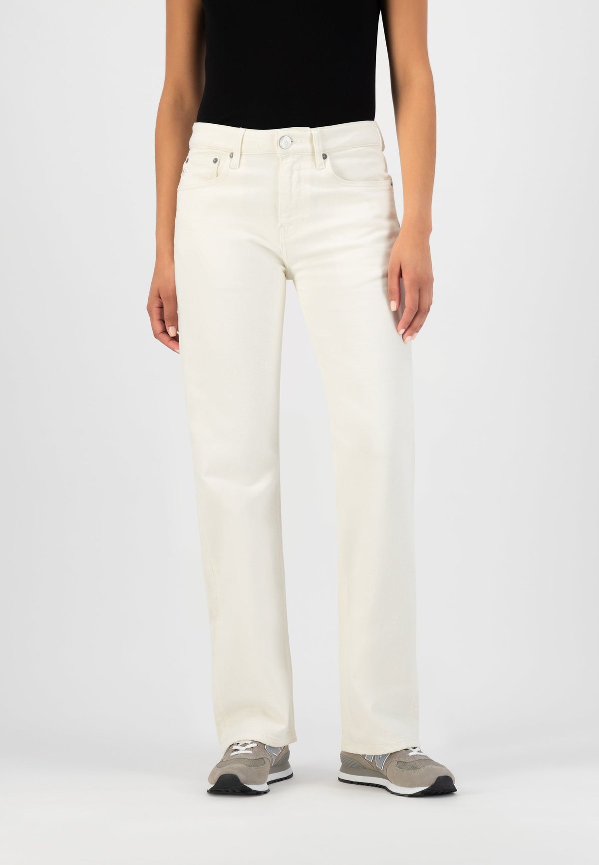High-waisted white denim jeans styled with a black sleeveless top and gray sneakers, showcasing a casual modern look.