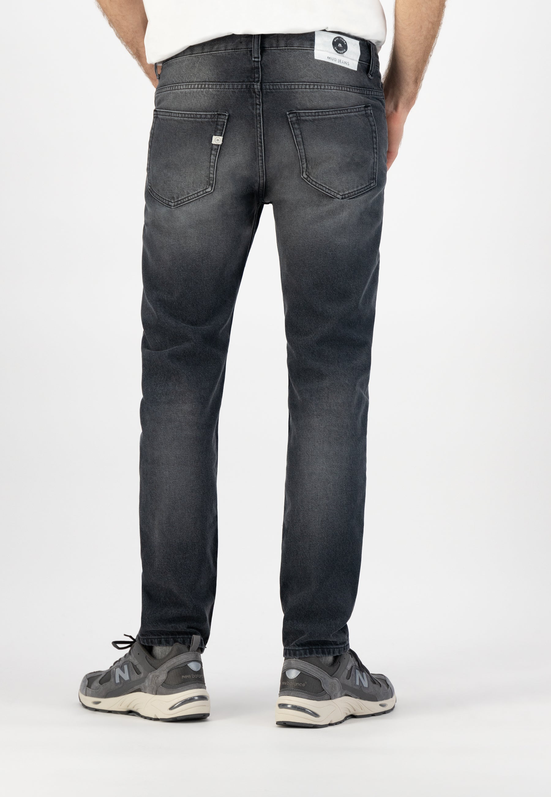Sustainable MUD Jeans crafted from organic cotton in dark denim, classic fit, styled with a gray sweater.