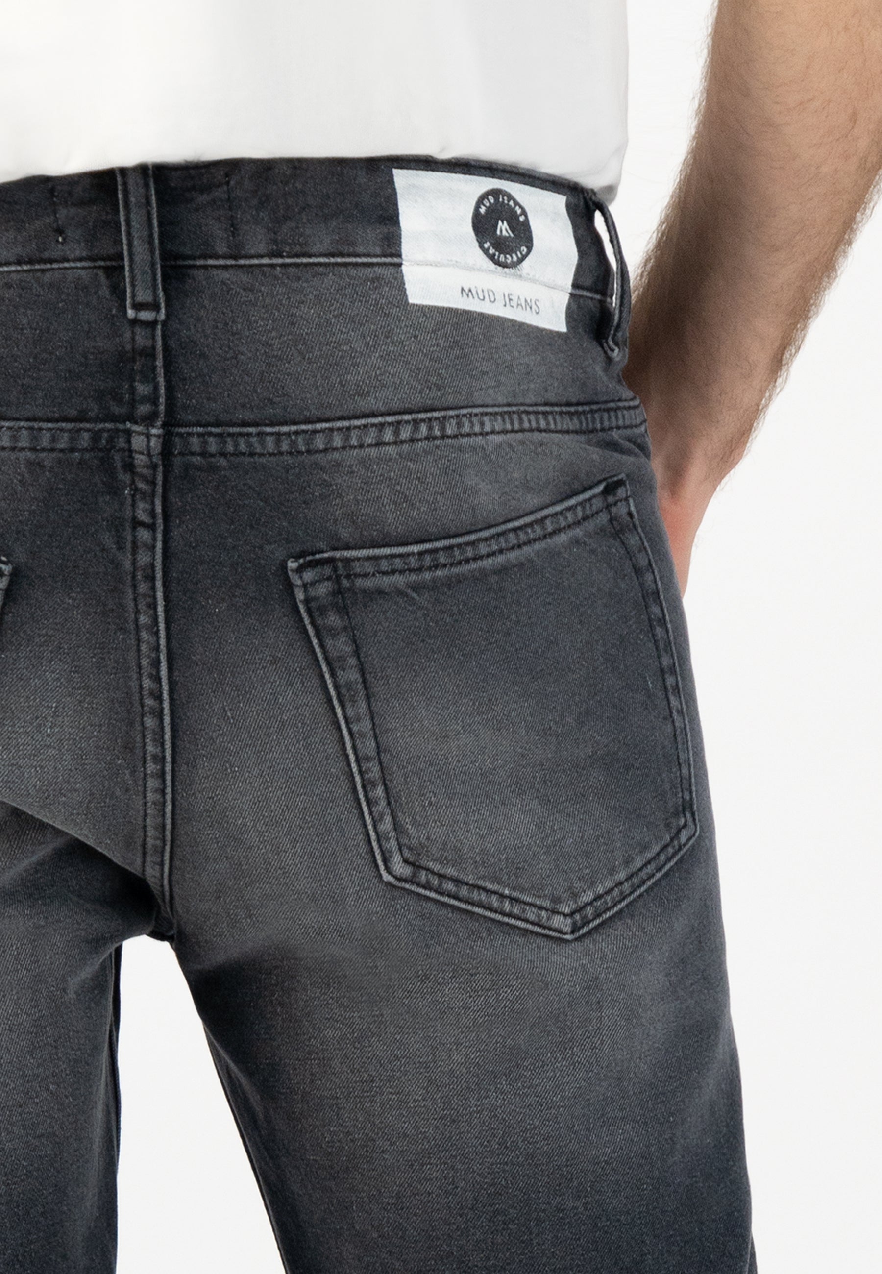 Sustainable MUD Jeans in dark gray, crafted from organic cotton, ethical fashion paired with a gray sweater.