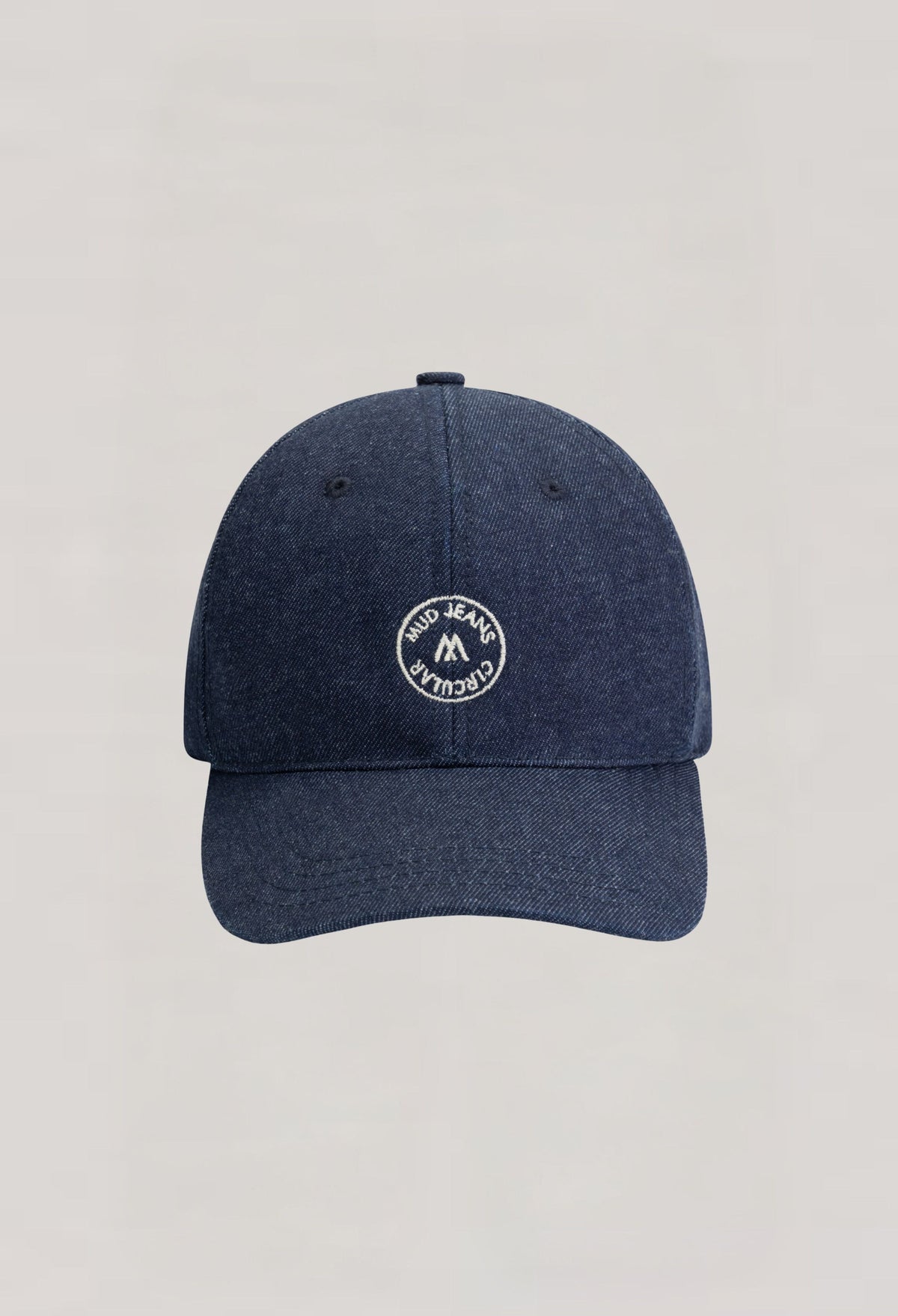 Dark blue denim cap by MUD Jeans featuring a circular patch logo, highlighting sustainable fashion and casual style.