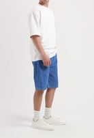 Sustainable MUD Jeans crafted from organic cotton, featuring dark blue denim in a modern fit, paired with white sneakers.