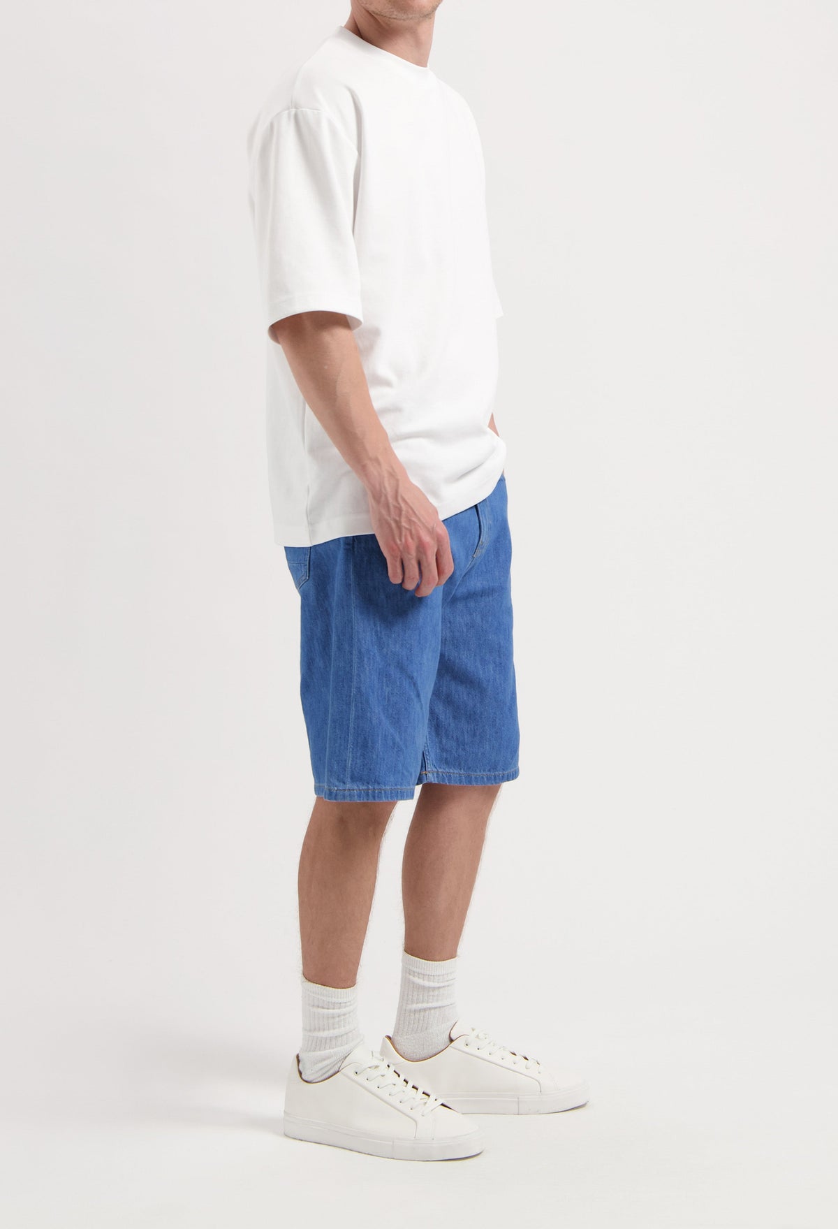 Sustainable MUD Jeans crafted from organic cotton, featuring dark blue denim in a modern fit, paired with white sneakers.