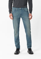 Sustainable MUD Jeans crafted from organic cotton, featuring classic blue denim, paired with a white shirt.