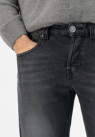 Sustainable MUD Jeans shorts in light olive, crafted from ethical materials, styled with a white t-shirt and sneakers.