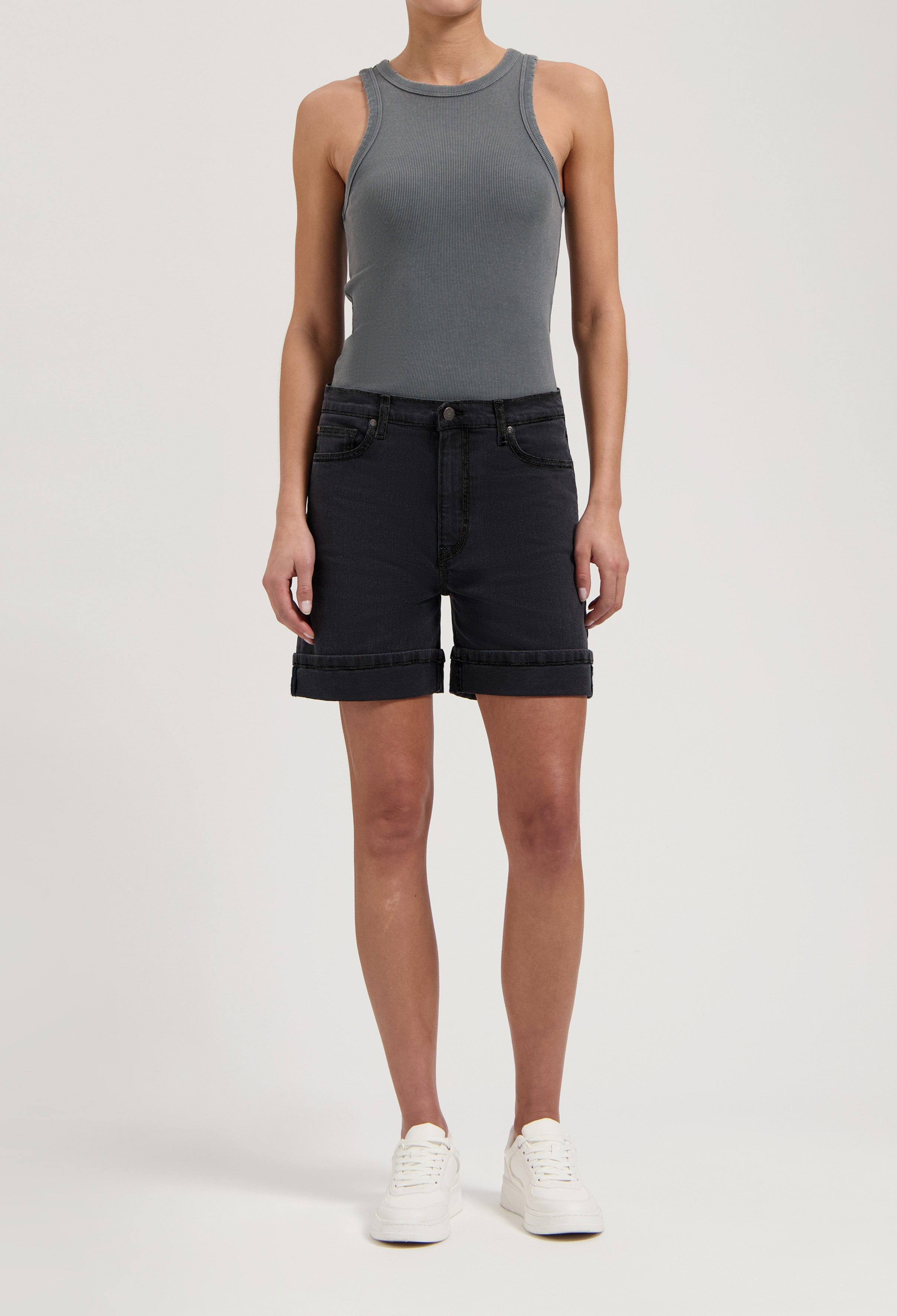 Gray sleeveless ribbed top paired with black denim shorts, highlighting casual summer fashion with white sneakers.