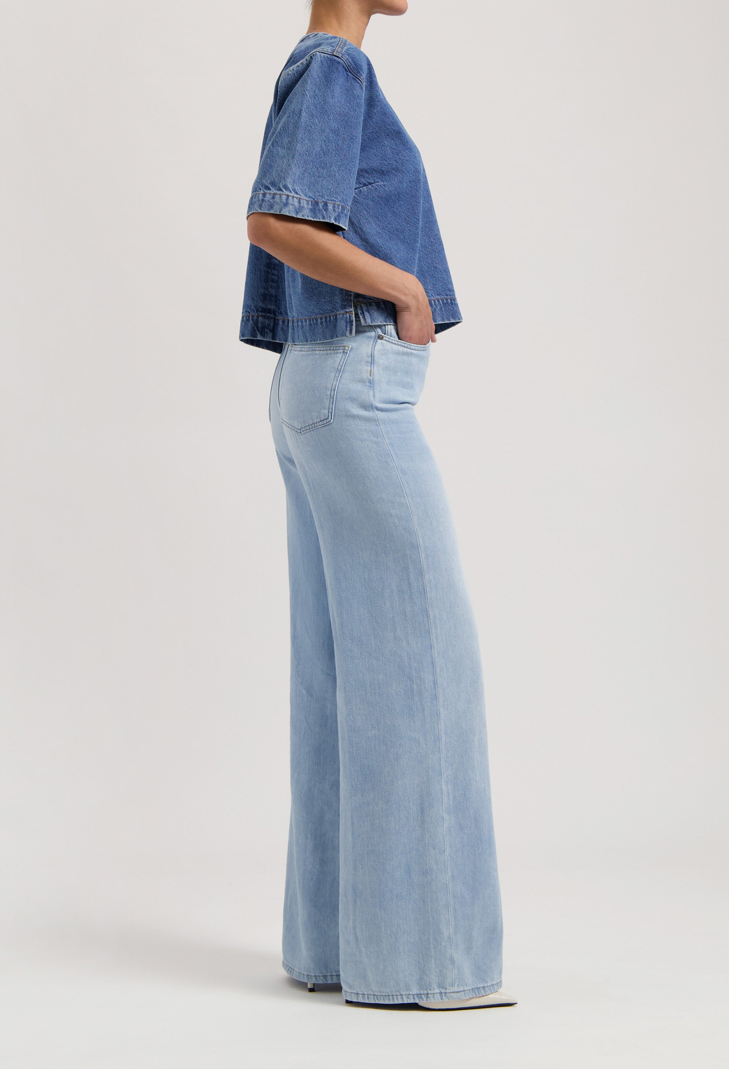 Wide-leg jeans in light blue denim, worn with a short-sleeve indigo denim top, showcasing casual and loose-fit style.